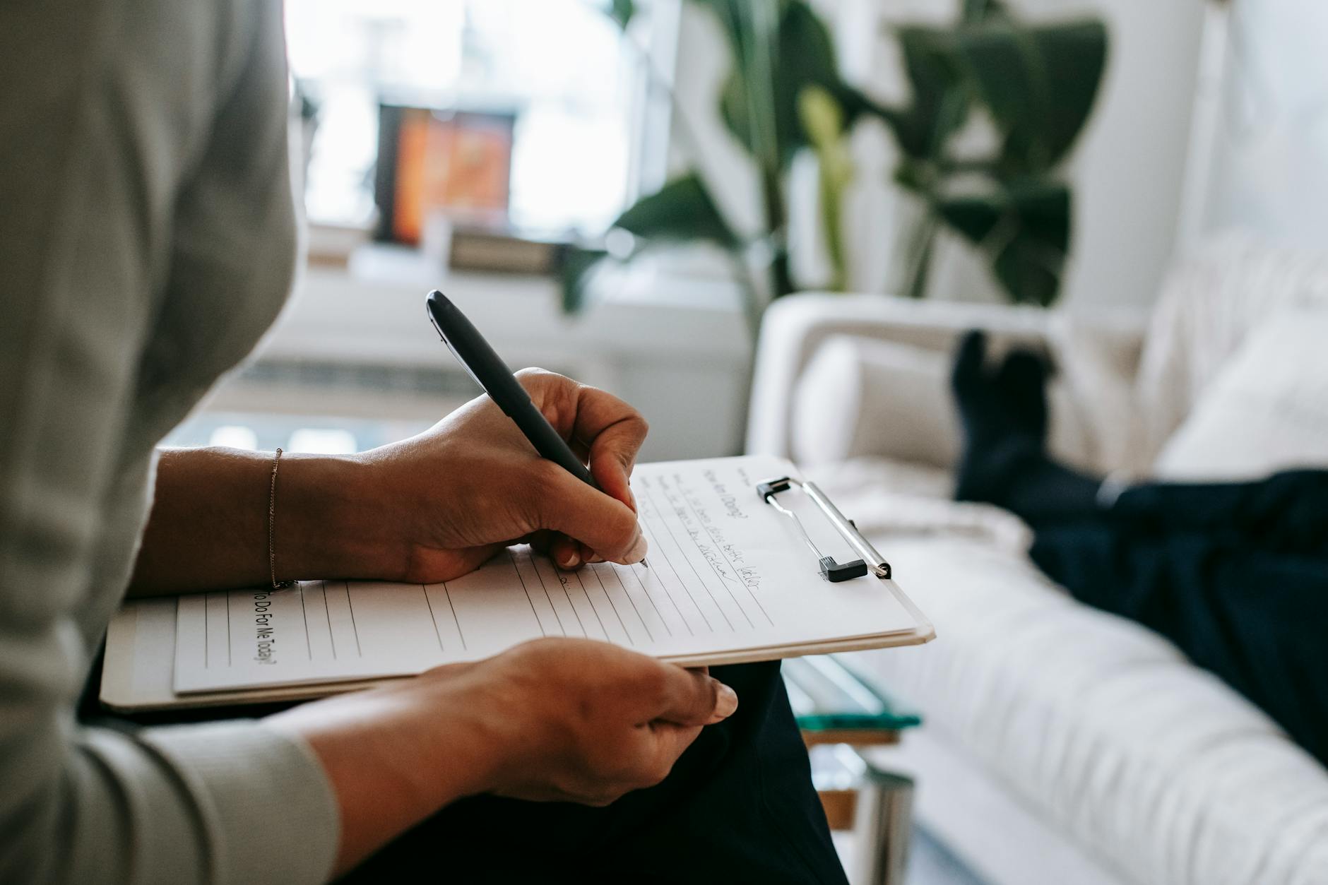 psychologist writing on clipboard during session