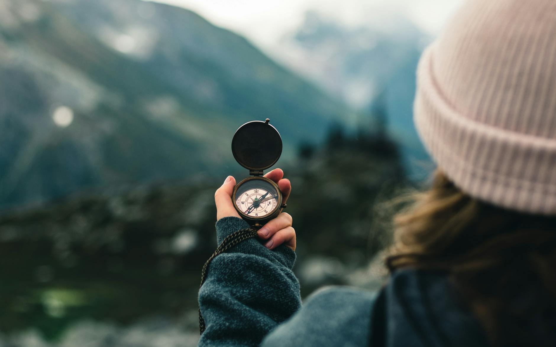 woman checking compass on trail