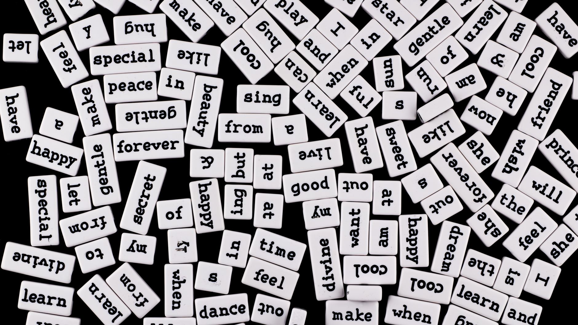 scattered word tiles on black background